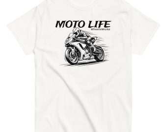 May include: A white short-sleeve t-shirt featuring a black graphic of a motorcycle rider in motion. The text MOTO LIFE is printed in a bold font above the motorcycle, with the smaller text WheelieWorks positioned to the right of the main title.