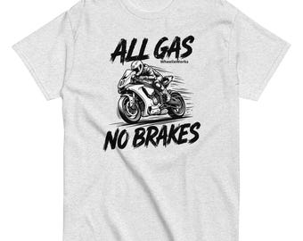 May include: A light gray heather t-shirt featuring a black and white graphic of a motorcycle rider in motion. The text ALL GAS is printed above the motorcycle, and NO BRAKES is printed below. The small text WheelieWorks appears near the rider.
