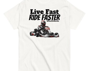 May include: A white t-shirt featuring a graphic of a go-kart driver wearing a helmet and racing suit in a red and black kart labeled 07. Above the graphic, the text reads Live Fast RIDE FASTER, with the word WheelieWorks printed below.