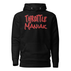 May include: Black hoodie with a front pocket and a drawstring hood. The hoodie features the red text "THROTTLE MANIAK" in a bold, stylized font. The design is centered on the chest.