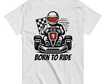 May include: A light gray t-shirt featuring a black and red graphic of a go-kart driver wearing a helmet, holding a steering wheel with the number 1, and a checkered flag. The text WheelieWorks and BORN TO RIDE are printed in black.