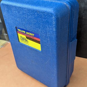 May include: A blue plastic case with a textured surface. The case has a rectangular label that reads "YELLOW JACKET GAS PRESSURE TEST KIT" and the Ritchie logo. The case is closed and appears to be a tool case.