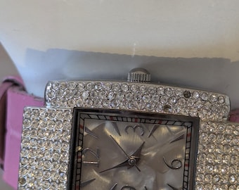 Reloj Paris Hilton Y2K con diamantes de imitación y correa rosa. Moda vintage de principios de la década de 2000.