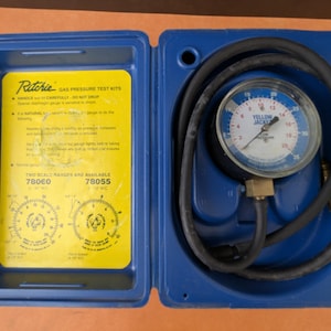 May include: A blue Ritchie gas pressure test kit with a yellow insert. The kit includes a pressure gauge with a black hose and the text "YELLOW JACKET". The kit is open, revealing instructions and two scale ranges.