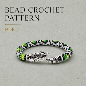 Op de afbeelding: Een kralenhaakpatroon PDF met een armband in een herhalend geometrisch patroon van zwarte, witte en limoengroene kralen. De armband eindigt in een zilverkleurige metalen sluiting in de vorm van een slangenkop met gedetailleerde schubben.