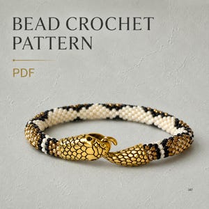 以下が含まれることがあります： ビーズクロッシェパターンのPDFで、蛇の形をしたゴールドメタルの留め具が付いたブレスレットです。ブレスレットは白、黒、メタリックゴールドの小さなビーズを繰り返し使用して作られており、質感のある円筒形の蛇のようなボディを形成しています。