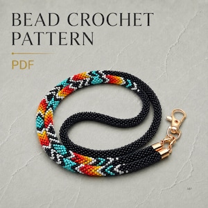 Op de afbeelding: Een kralenhaakpatroon PDF met een ketting gemaakt van kleine zwarte, rode, oranje, gele en turquoise kralen in een geometrisch patroon. De ketting is voorzien van een goudkleurige metalen karabijnsluiting aan het uiteinde.