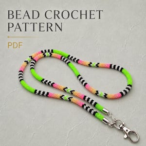 Könnte beinhalten: Ein Perlen-Lanyard mit einem sich wiederholenden Muster aus neongrünen, schwarzen, weißen und von Pink zu Orange verlaufenden Perlen. Das Lanyard ist mit einem silberfarbenen Karabinerhaken aus Metall versehen. Der Text BEAD CROCHET PATTERN PDF ist sichtbar.
