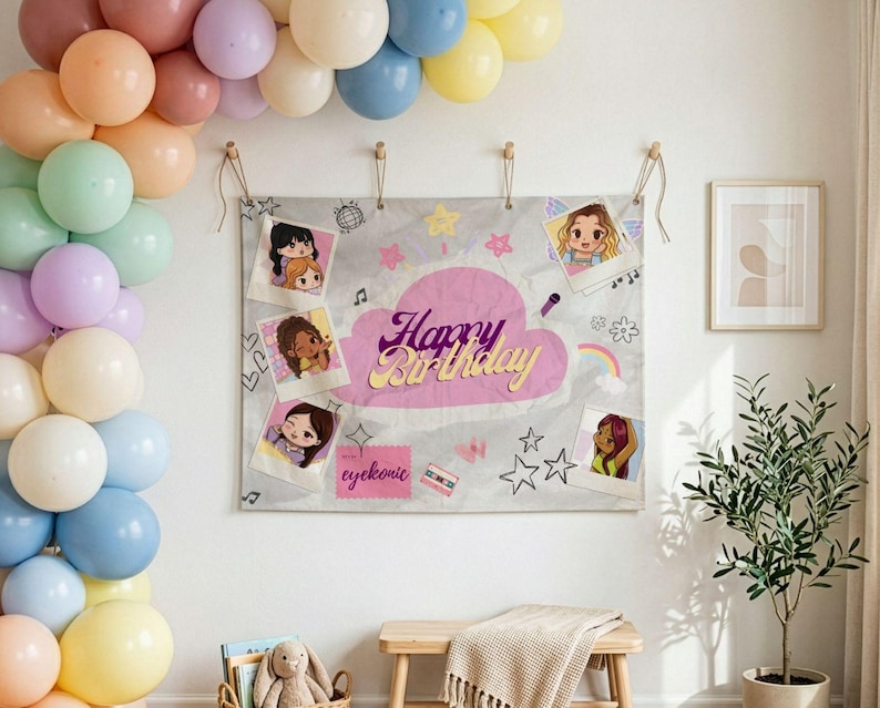 Op de afbeelding: Een verjaardagsachtergrond met de woorden "Happy Birthday" in roze en goud, omringd door cartoon illustraties en foto's. Een ballonnenboog in pastelkleuren versiert de muur. De achtergrond is opgehangen met houten pinnen.