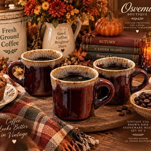 May include: A set of three brown stoneware mugs featuring a distinctive drip glaze pattern with a cream-colored rim. The mugs have a glossy finish, a sturdy handle, and a wide base, presented as a collection of vintage-style drinkware.