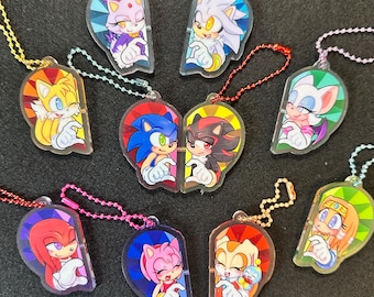 Puede incluir: Una colección de llaveros acrílicos coloridos con varios personajes de la franquicia Sonic the Hedgehog. Cada llavero tiene forma de medio corazón, con personajes como Sonic, Tails y Knuckles. Tienen accesorios de cadena de bolas de metal.