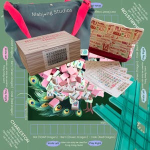 May include: A collection of Mahjong game items, including a wooden box of tiles, a tote bag, and a zippered pouch. The tiles are pink and white. The tote bag is gray with pink straps, and the pouch has a red trim.
