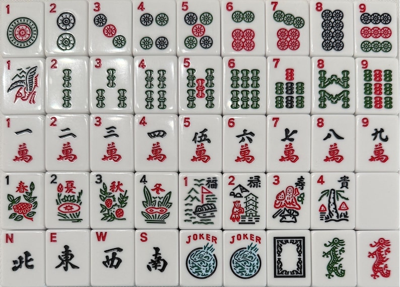 Pode incluir: Um conjunto completo de pe&ccedil;as de Mahjong brancas, apresentando v&aacute;rios s&iacute;mbolos, n&uacute;meros e caracteres em vermelho e verde. As pe&ccedil;as est&atilde;o dispostas em uma grade, mostrando os diversos desenhos e s&iacute;mbolos usados no jogo.