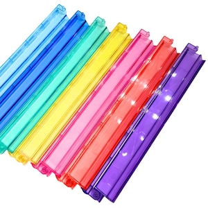 May include: A collection of colorful plastic document holders in a rainbow of hues. The holders are arranged diagonally, showcasing shades of blue, green, yellow, pink, red, and purple. Each holder has a clear, rectangular design with a clasp.