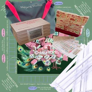May include: A Rose Dragon Mahjong set with pink tiles, a wooden box, and a gray tote bag with pink straps. The set includes game instructions and a patterned pouch. The background features peacock feather designs.