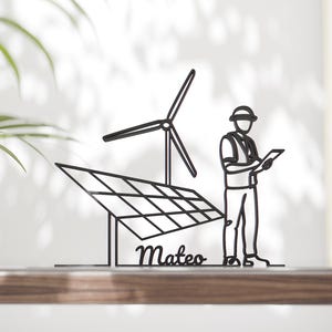 Pode incluir: Peça de arte em metal preto que retrata um painel solar, uma turbina eólica e um engenheiro com um tablet. O nome "Mateo" está escrito abaixo do painel solar. Uma representação minimalista de energias renováveis.