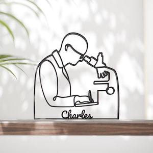 Op de afbeelding: Een witte keramische mok met een zwart handvat en de tekst "But first, coffee" in een zwarte, handgeschreven lettertype. De mok staat op een wit oppervlak.