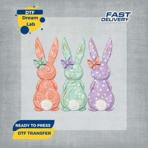 May include: Three Easter bunny designs in coral, mint green, and lavender. Each bunny has a bow and decorative patterns. The image includes the text "DTF Dream Lab", "Fast Delivery", and "Ready to Press DTF Transfer".