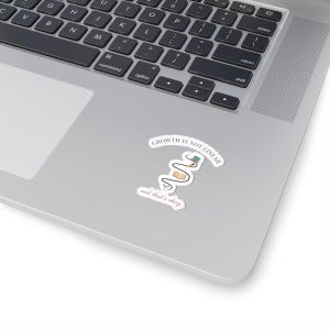 May include: A white sticker on a laptop with the text "GROWTH IS NOT LINEAR" and "and that's okay." The sticker features a stylized illustration of a plant with books and a notebook. The laptop is silver and black.