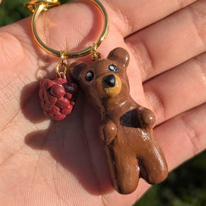 May include: A white ceramic mug with a black handle and the text "But First, Coffee" in a black, handwritten-style font. The mug is on a white surface.