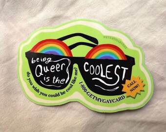 Puede incluir: Una pegatina con un borde verde lima que presenta un par de gafas de sol negras con lentes de arcoíris. El texto dice "being Queer is the COOLEST" y "¿deseas ser tan guay como yo?" con un número de teléfono.