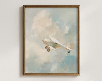 Puede incluir: Impresión enmarcada que representa un avión biplano vintage volando por un cielo pastel. La obra de arte muestra un avión color crema con ruedas marrones sobre un fondo de nubes suaves azules y blancas. El marco es de color dorado cálido.