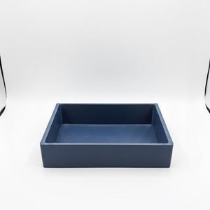 May include: A navy blue rectangular tray with a matte finish. The tray has a simple, modern design and is suitable for organizing items. The tray's dimensions are approximately 30 cm long, 20 cm wide, and 5 cm deep.