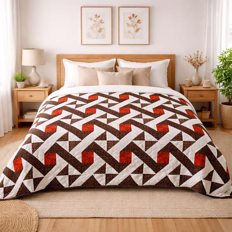 May include: A geometric patterned quilt in shades of brown, white, and red covers a bed. The quilt features a repeating design of triangles and squares. The bed is made up with pillows and a wooden headboard. Two framed botanical prints hang on the wall.