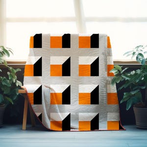 Może przedstawiać: Narzuta z powtarzającym się geometrycznym wzorem pomarańczowych, białych i czarnych kwadratów ułożonych w siatkę. Projekt tworzy trójwymiarowy efekt sześcianu na powierzchni tkaniny, która wykończona jest subtelną, pikowaną fakturą.