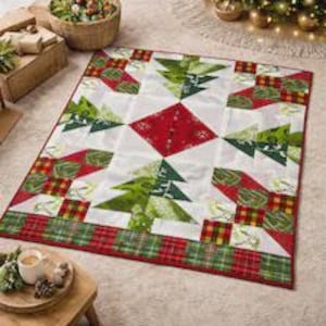 Könnte beinhalten: Ein rechteckiger Quilt mit einem sich wiederholenden Muster aus grünen Weihnachtsbäumen auf weißem Grund, akzentuiert durch rote Rautenformen und Ränder aus rot-grün-gelbem Schottenkaro-Stoff. Das Design enthält verschiedene Grüntöne.