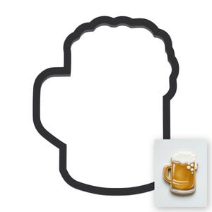 Puede incluir: Un cortador de galletas negro con forma de jarra de cerveza, con un contorno grueso y un asa en el lado izquierdo. En la esquina inferior derecha, un pequeño cuadrado muestra una galleta terminada con forma de jarra, líquido dorado y espuma.