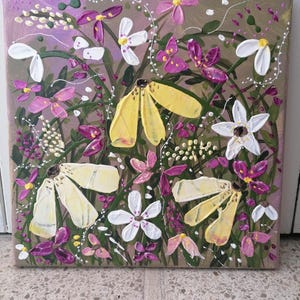 Könnte beinhalten: Ein Acrylgemälde auf Leinwand mit einer strukturierten Blumenszene, bestehend aus großen gelben Blütenblättern, kleinen weißen fünfblättrigen Blumen und leuchtend violetten Blüten vor einem taupefarbenen Hintergrund mit weißen Ranken.