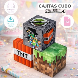 May include: Three Minecraft-themed cube boxes stacked on top of each other. The top box is gray with a Minecraft logo and a grassy scene. The middle box is orange with "TNT" printed on it. The bottom box is green and brown, resembling grass and dirt.
