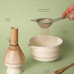 May include: A matcha tea set featuring a bamboo whisk on a ceramic stand, a white ceramic bowl, a stainless steel mesh strainer, and a bamboo spoon. Text labels identify the materials as bamboo, stainless steel, and ceramics in the image.