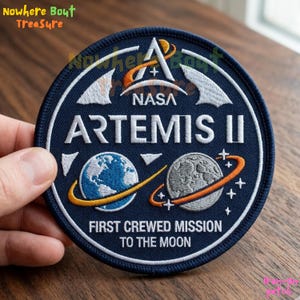 May include: A white ceramic mug with a black handle and the text "But First, Coffee" in a bold, black font. The mug is set against a blurred background, suggesting a cozy setting.