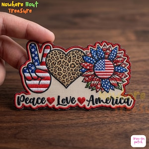 May include: Embroidered patch featuring a peace sign, a leopard print heart, and a sunflower with an American flag design. The text "Peace Love America" is included in the design.