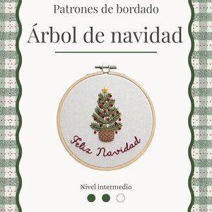 Puede incluir: Una guía de patrones de bordado titulada Patrones de bordado Árbol de navidad, que muestra un bastidor de madera circular con un árbol de Navidad verde bordado, adornos rojos, una estrella amarilla y el texto en cursiva Feliz Navidad.