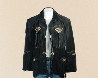 May include: Black suede jacket with fringe and decorative accents. The jacket features a collared neckline, button closures, and detailed embellishments with a Western-inspired design. The jacket is displayed on a mannequin.