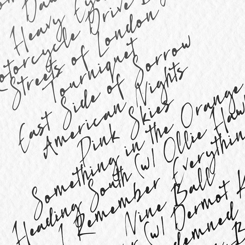 以下が含まれることがあります： 白紙に黒の手書き文字が書かれたクローズアップ。 「Motorcycle Drive」、「Streets of London」、「American Skies」などのフレーズが含まれています。 全体的なテーマは芸術的でテキスト的です。