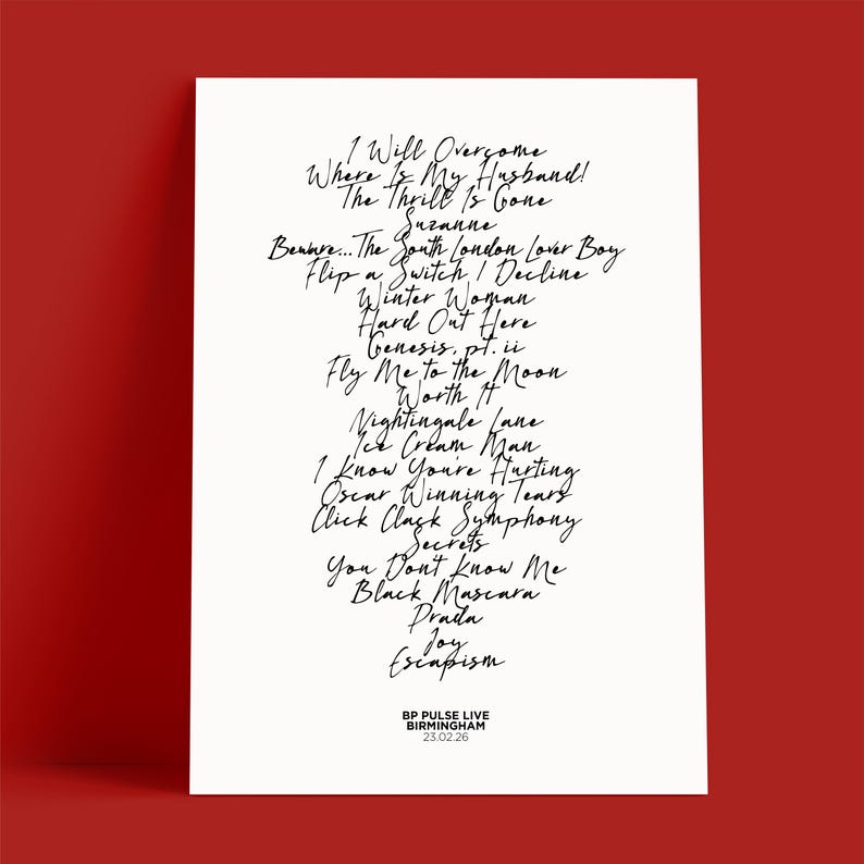 K&ouml;nnte beinhalten: Ein wei&szlig;es Poster mit handgeschriebenen Songtiteln in schwarzer Schrift, darunter "Fly Me to the Moon" und "Black Mascara". Das Poster enth&auml;lt auch den Text "BP PULSE LIVE BIRMINGHAM 23.02.26" am unteren Rand.