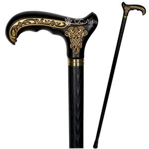 Full-view studio photo of the Celtic cane on a white background. The carved handle with gold engraving and the straight black shaft form a clean silhouette. The composition highlights balance, ergonomic shaping and the decorative Celtic pattern, presenting the cane as both a reliable mobility tool and a refined handcrafted item.