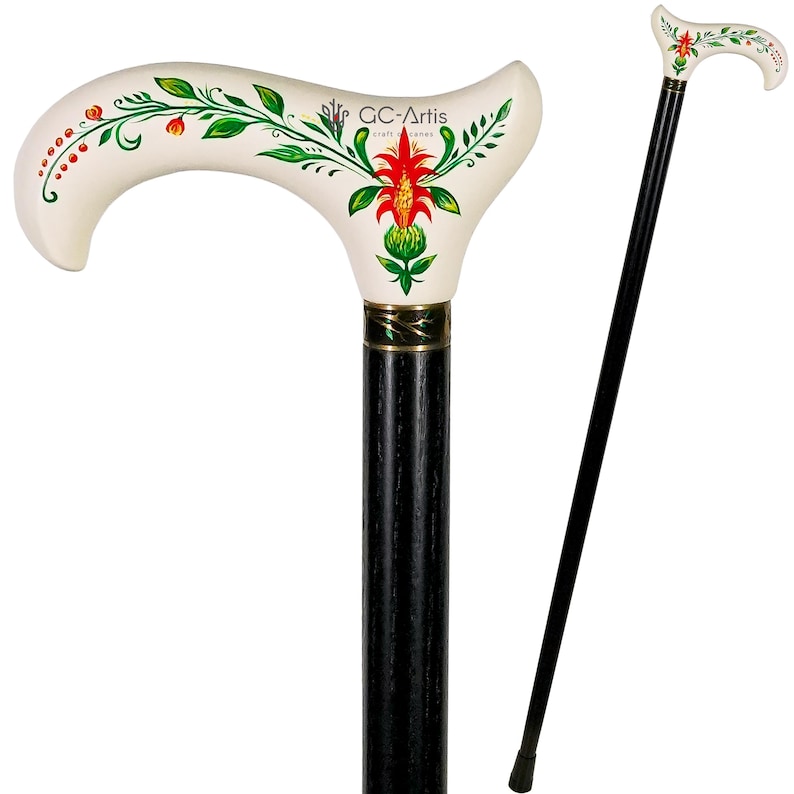 Puede incluir: Un bast&oacute;n de madera blanco con un eje negro y un dise&ntilde;o floral. El mango tiene forma de cayado de pastor y presenta una flor roja con hojas verdes.