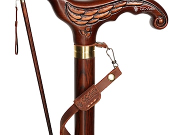May include: A dark brown wooden walking cane with a bird-shaped handle. The handle features carved details of a bird's wings and head. A leather strap with a metal clasp and a small leather tag is attached to the cane. The cane is approximately 37 inches tall.