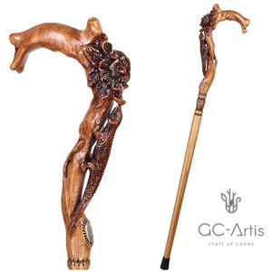 Full-view studio image of the Floral Lizard cane on a white background. The carving includes an elongated lizard form intertwined with flowers and foliage, creating a flowing vertical composition down the upper shaft. The warm wood tones and subtle painted areas highlight the expressive handcrafted style and balanced silhouette of the cane.
