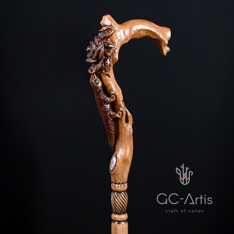 Studio photo of the Floral Lizard cane on a dark background showing the carved handle and upper shaft. The lizard figure rises from the top with curved movement and textured detail. Floral carvings blend with the warm wood surface, giving the cane a sculptural, organic aesthetic suitable for collectors and daily use.