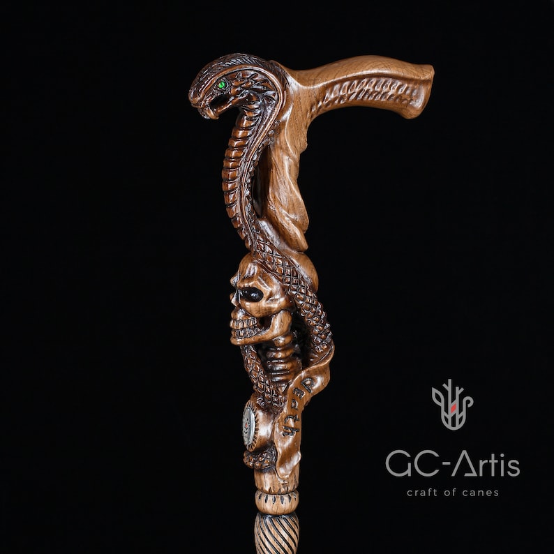 Close-up of snake and skull carved cane on black background. Wooden surface polished to deep brown tone enhances carved textures and details. GC-Artis walking stick combines artistry, gothic symbolism, and usability.