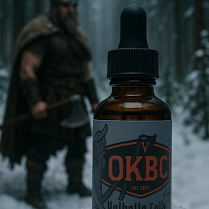 May include: A brown glass bottle with a black dropper, labeled "OKBC Valhalla Calls" with a Viking illustration. The bottle is 1 fl oz. A blurred image of a Viking warrior stands in the background.