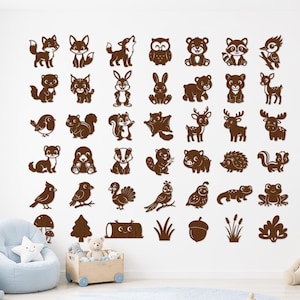 May include: A collection of brown wall decals featuring various woodland animals, birds, and forest elements arranged in a grid. The set includes illustrations of foxes, bears, deer, squirrels, owls, a mushroom, a tree, a log, and an acorn.