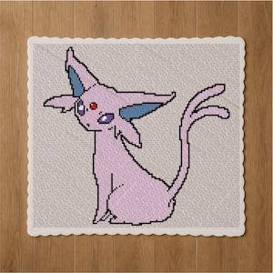 Op de afbeelding: Een gehaakte vierkant met een gepixeld Espeon-ontwerp. De Espeon is voornamelijk lichtpaars met blauwe accenten op de oren en een rood oog. De vierkant heeft een geschulpte rand en staat tegen een lichtgrijze achtergrond.