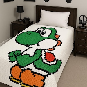 Puede incluir: Una colcha blanca con una imagen pixelada de Yoshi, el personaje del dinosaurio verde. La habitación tiene una cabecera de madera oscura, mesitas de noche y arte mural que dice "Eat Sleep Game Repeat".